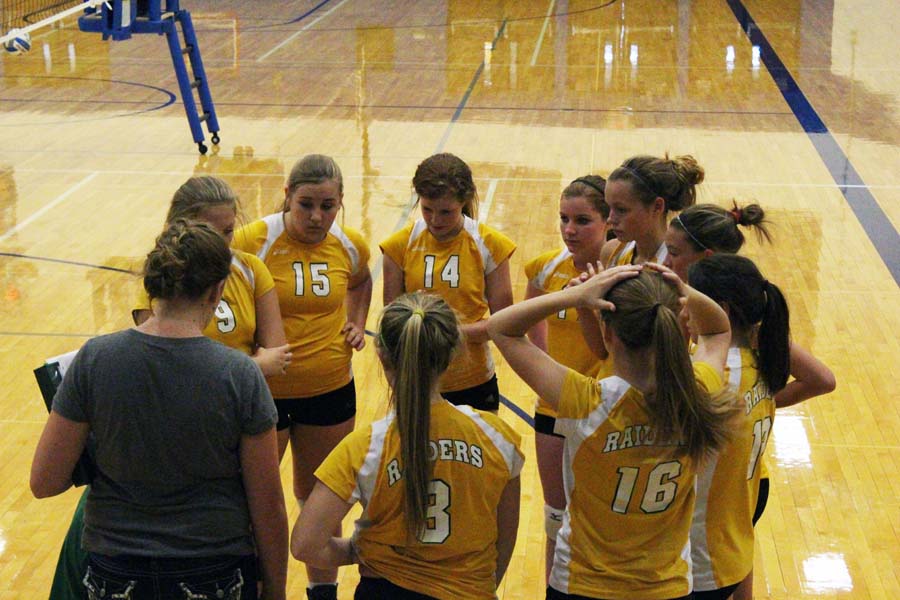 In a huddle, the Freshman volleyball team gets hyped up before the beginning of the game. The lady Raiders played against Olathe South. Photo By Jesse York