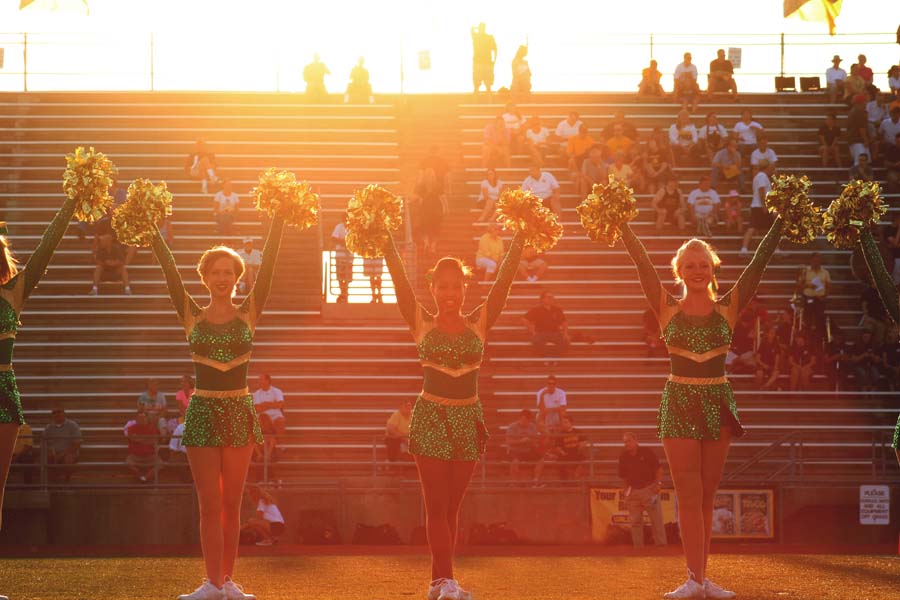 In the spotlight, Seniors, Rachel Rosenstock, Nia Madison, and Olivia Feathers perform during the pregame show. This was the first pregame show of the varsity football season against the defending state champions.