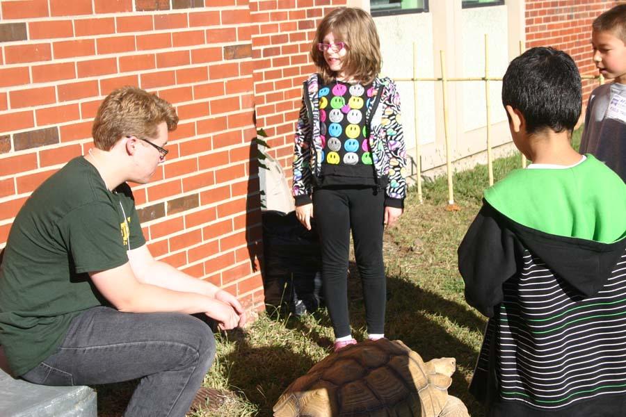 During the first elementary school visit, junior Gavin Carter show the students the turtle Nortan. The kids go to Apache Elementary School.
