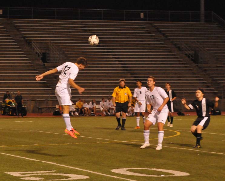 Head butting the ball, senior and varsity player Austin Prauser leaps high in an attempt to defend the goal.