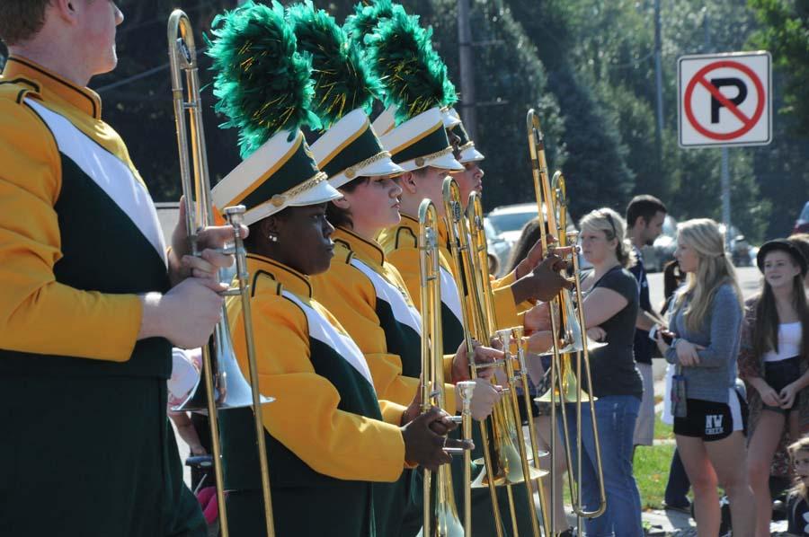 Holding their trombones, the horn section waits for their enrty to continue playing at the Overland Park Parade. SMS was one of many other school marching bands.