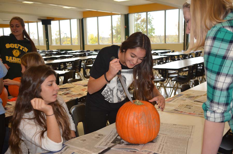 Having a blast, Senior Iffet Genc carves pumpkins with the rest of the forgein exchange students for the second international club meeting. Every year the international club has all the foregin exchange students get together and carve pumpkins. This was many of the foregin exchange students first time carving pumpkins.
