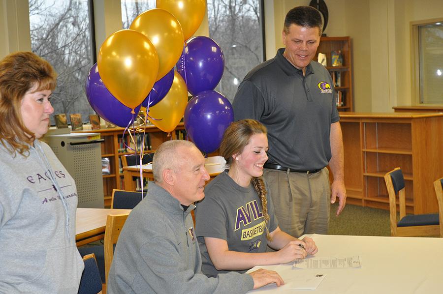 Senior Nikki Norton is accompanied by her parents and her future coach as she makes her commitment to Avila University where she will continue to play basketball beyond her high school career.