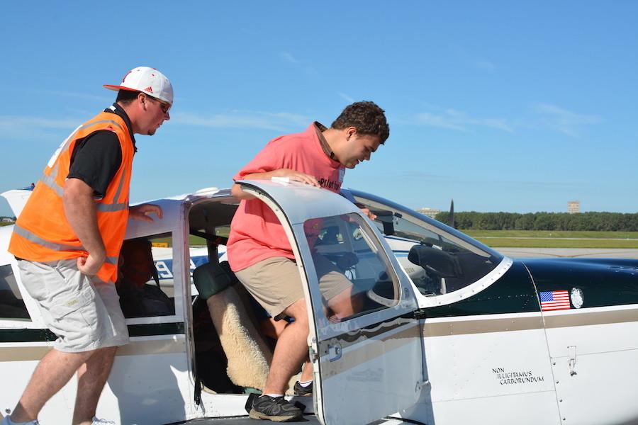 Getting into his seat, sophomore Wesley Hansen gets ready to ride in the plane. Challenge air allows kids with special needs opportunitys to ride in planes with volunteer pilots. 