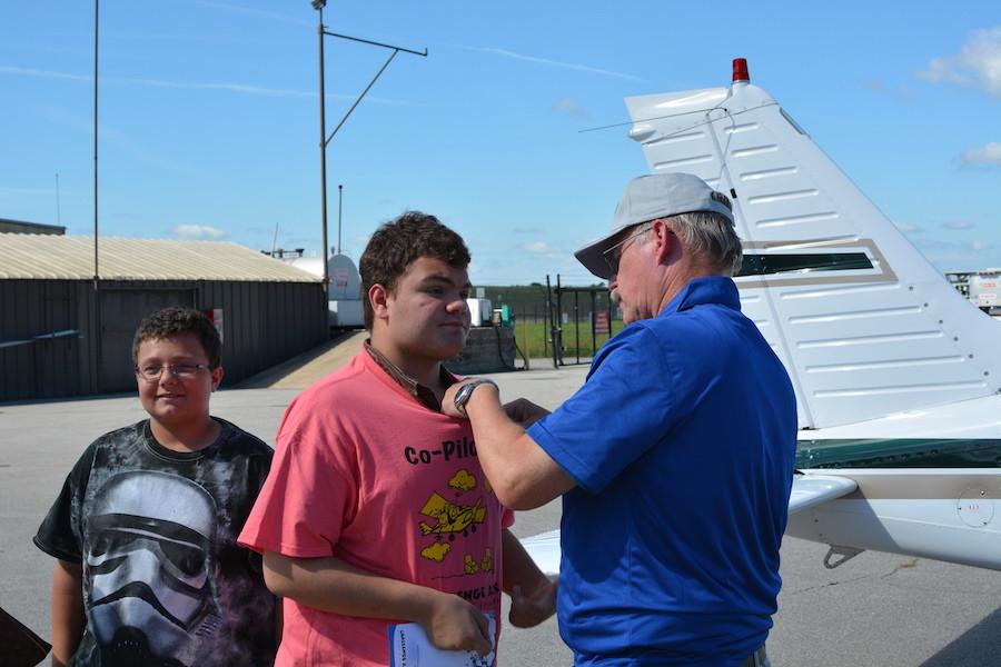 After the plane ride, sophomore Wesley Hansen gets his wings badge from his pilot. Hansen was able to fly the plane for a few minutes in the air. 