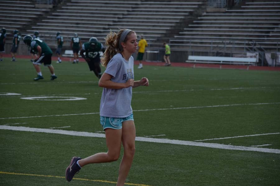 Junior Corinne Rogers running the final length of the track in warmup.