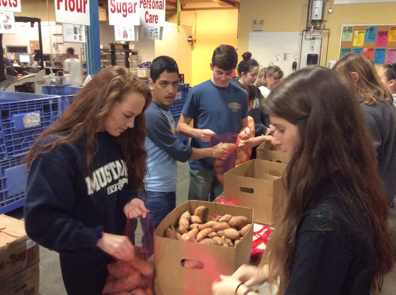 During the IPS trip to Harvesters, students Emma Elliott, Ivan Jiminez, Kyle Ham, and Molly Wisker bag sweet potatoes for distribution to the needy. photo by Andrew Symonds