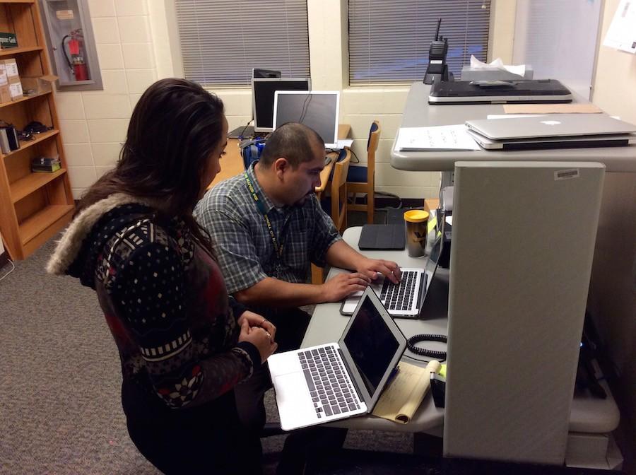 New network analyst Fabian Solis helps sophomore Rose Loback with a computer problem.