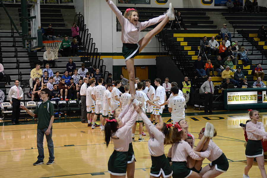Freshman Bergen Cooper hits a heel stretch cheering for the varsity starters at the Pink Out game  Feb. 9.