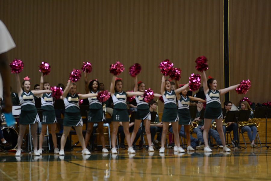 During half time, the middle school cheerleaders cheer on the middle school boys basketball team with their pink pom-poms during the Pink Out game. 