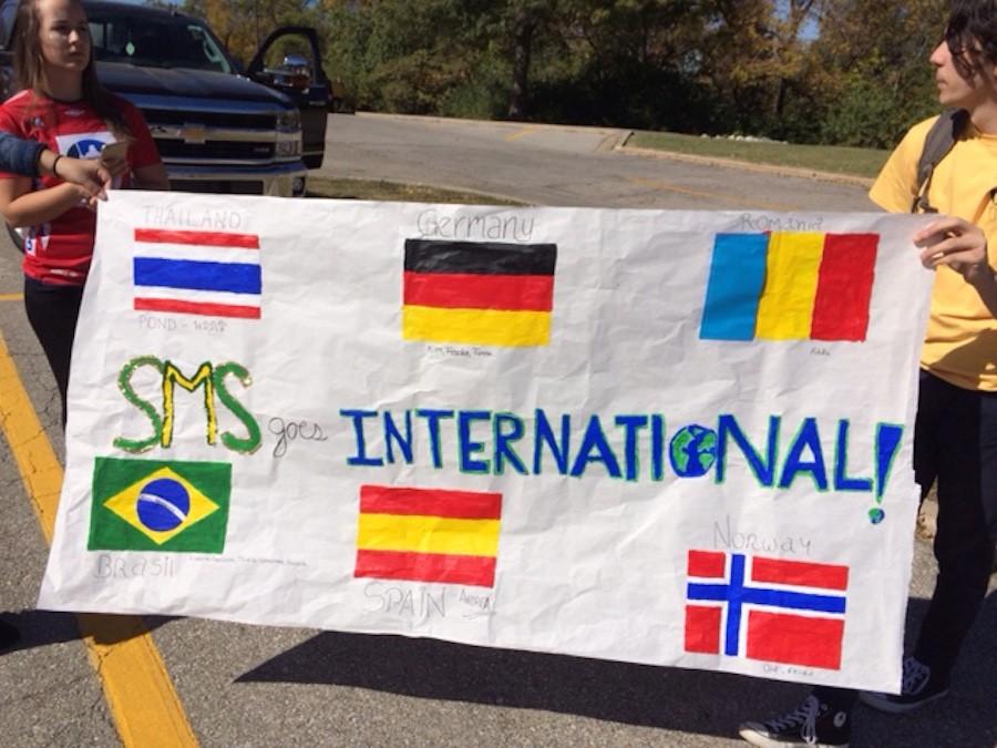 Exchange students celebrate the 50th school anniversary at the Homecoming Parade with the International Club 