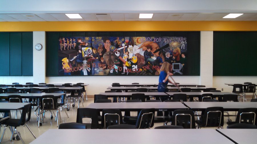 Janitor Jackie Casteel sweeps the cafeteria after lunch.