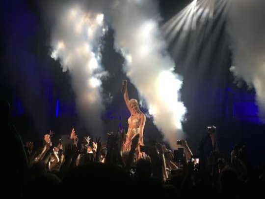 Famed singer Halsey raises her microphone as smoke goes off behind her during the performance of her song, Is There Somewhere. The performer was held up by the crowd at her Midland concert during the song as she finished her set. 