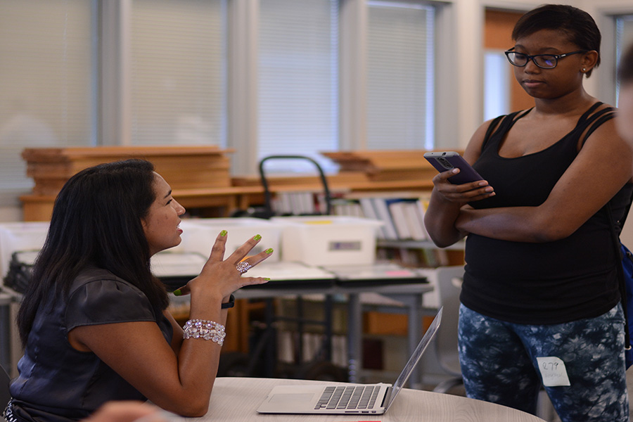 Figuring out computer distribution issues, vice principal Josie Herrera helps junior Angelique Allen get in contact with her parent to get her laptop. 