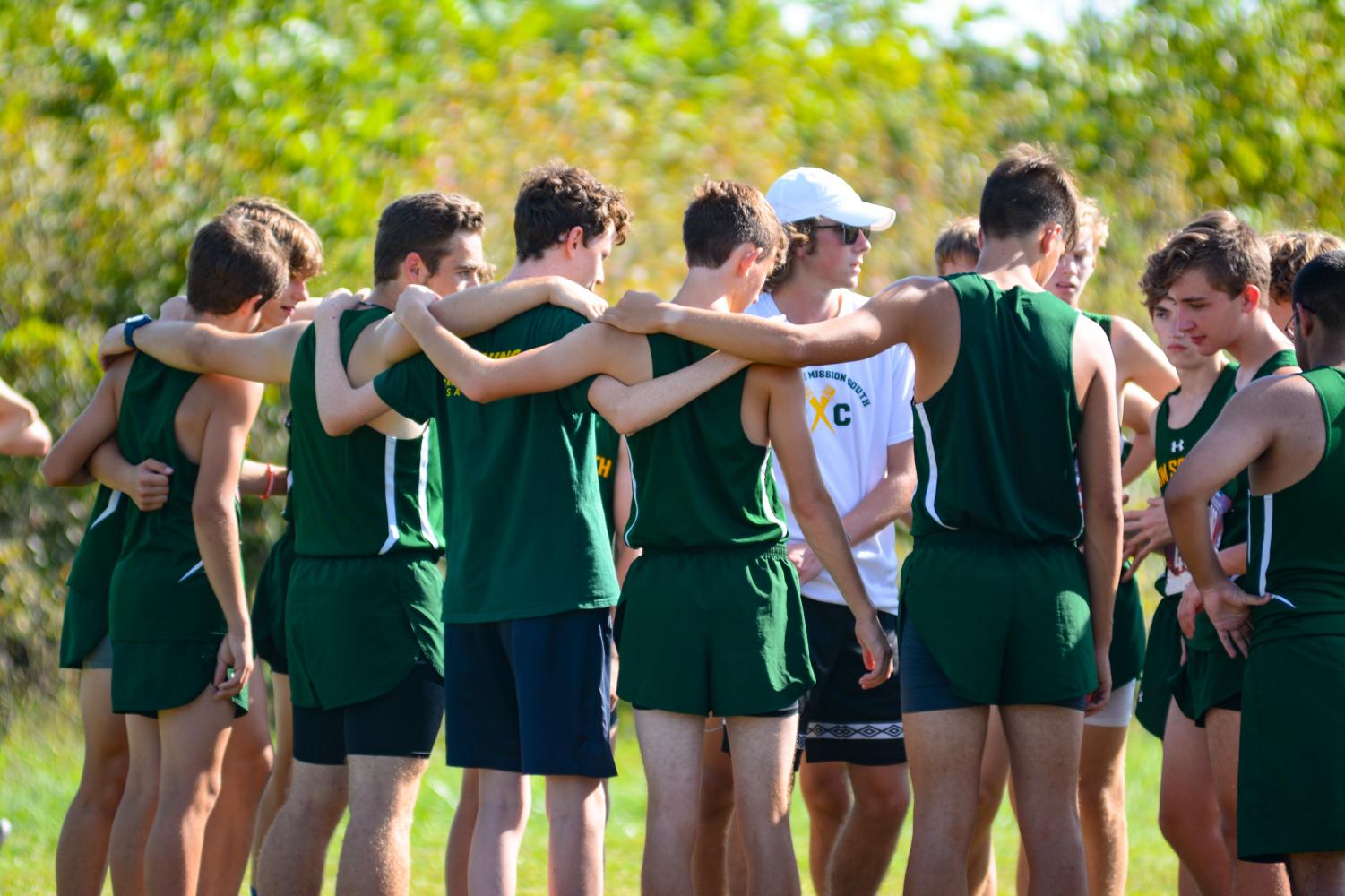 The boys huddle up at the top of the hill in SM park for the JV meet. On Sept. 16 the girls were just finishing up their meet as the alumni gives the boys their own pep talk before their race.