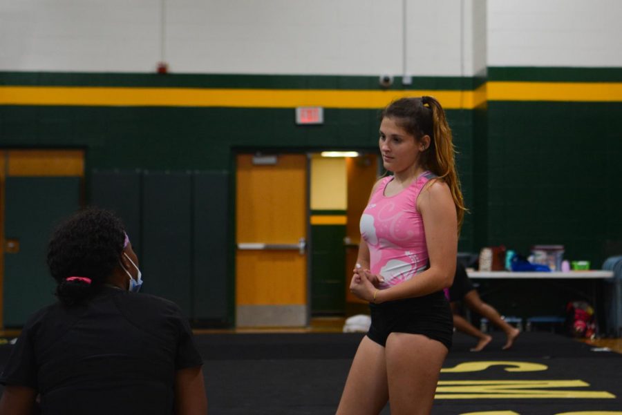 At practice, sophomore Rachel Brunk talks to coach Jess Mcmurray about her floor routine.
