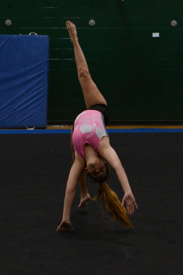 As she practices her floor routine, sophomore Rachel Brunk performs a back walkover.