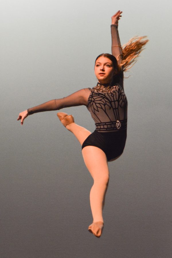 In the air, sophomore Eva Tuttle performs her jazz solo at the Innovative Dance Competition.