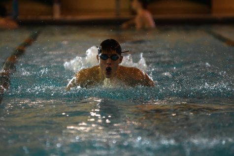 Gasping for air, senior Kyle Gellhaus practices butterfly during a morning practice on January 16 at Shawnee Mission South High School. Kyle was in the middle of a medley set half way through the 2 hour workout.