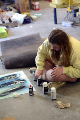 On Monday May first, in Mrs. Doughertys 5th hour Jewelry and Sculpting class,  senior Taylor Smith work on her art project on the floor with the door open to prevent the fumes from the spray paint spreading around the classroom.