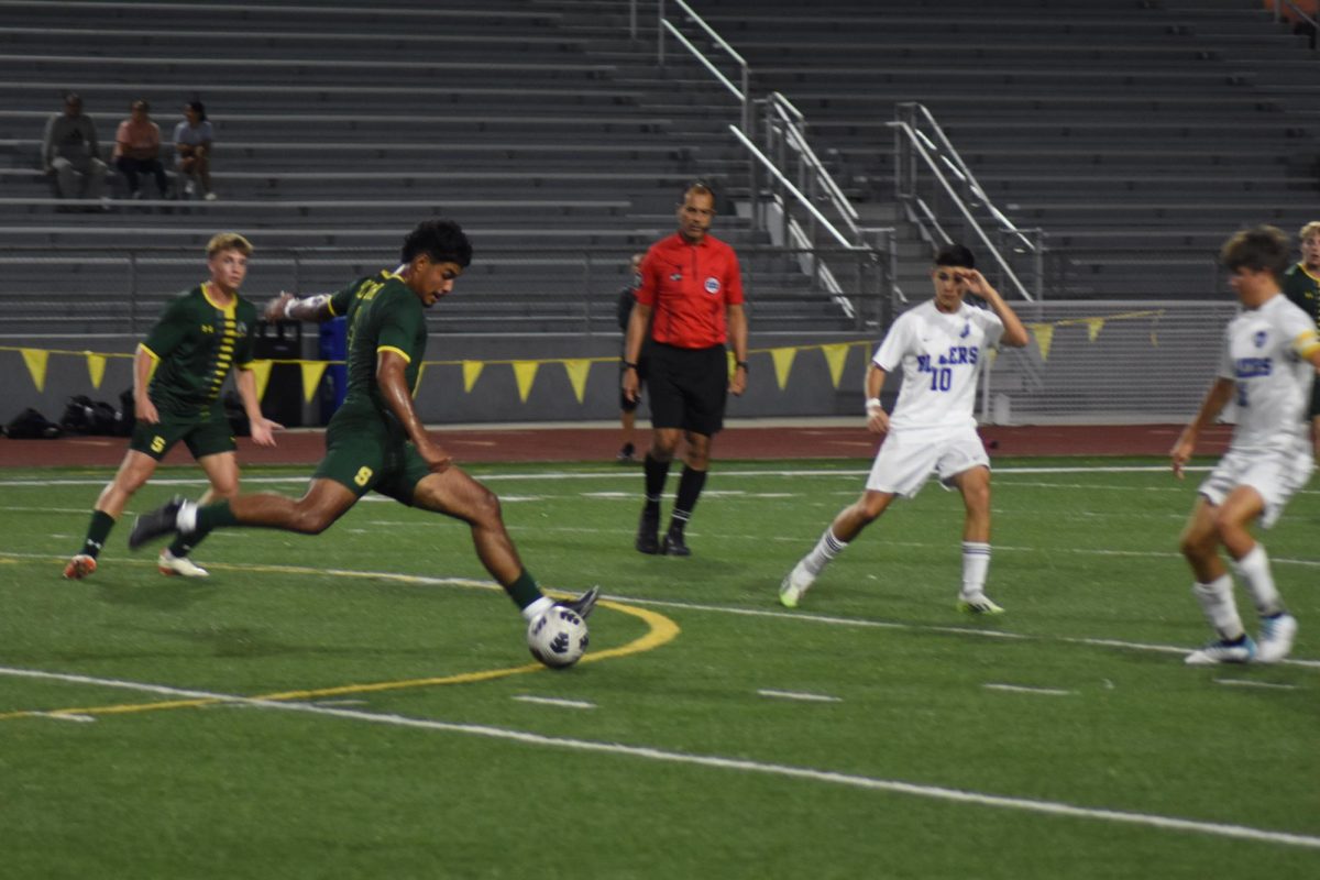 Junior Rudy Delgado kicks the ball from midfield.