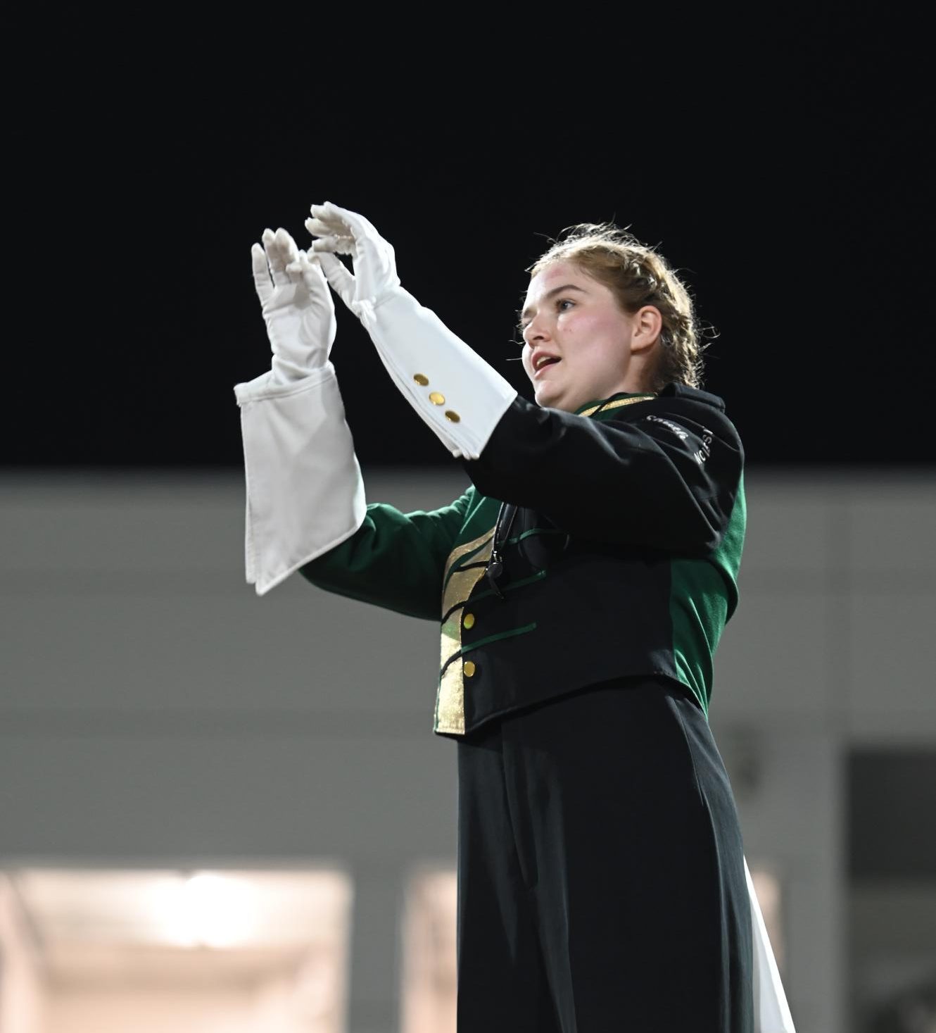 Drum Major Emma Kreuger conducts the band at a Friday football game.