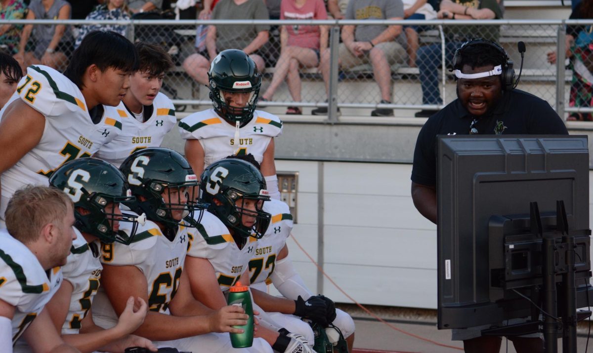 Members+of+the+offensive+line+listen+on+the+sidelines+while+coach+Terrale+Johnson+reviews+footage+during+the+varsity+football+game+against+Shawnee+Mission+North+on+September+1.