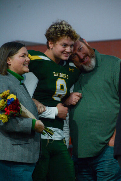 Before going on the field to get recognized on senior night, senior Evan Colwell and his Parents take in arms on October 25.