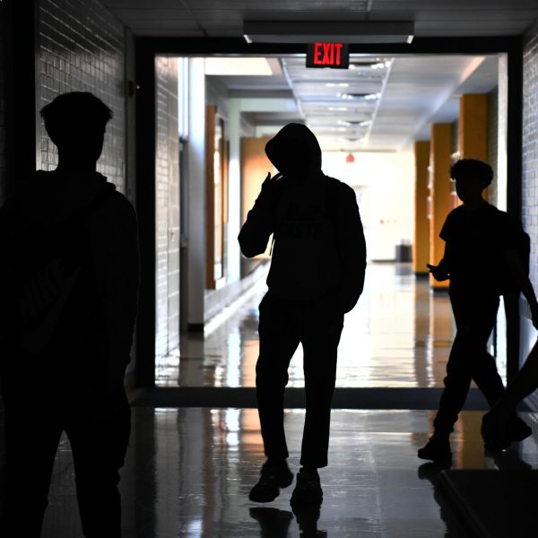 After grabbing their bags from the boys' locker room, students interact with one another while being led back to the cafeteria by teachers.