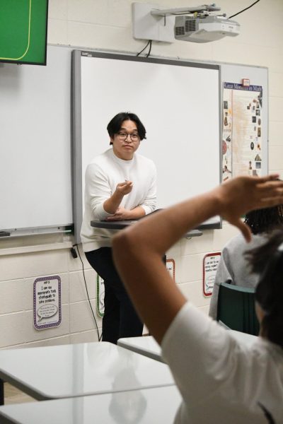 Asking his class a question, math teacher J Kim teaches his Integrated Alegbra/Geometry 2 class how to solve a problem.