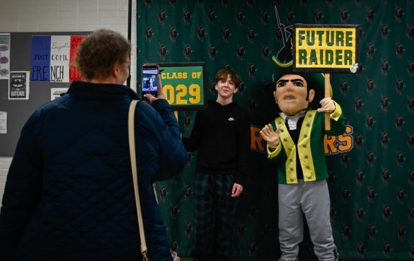 A mother captures a moment with her son and Rocky the Raider, at Come Look at South Night, as her son holds the future raider sign proudly representing the class of 2029. 