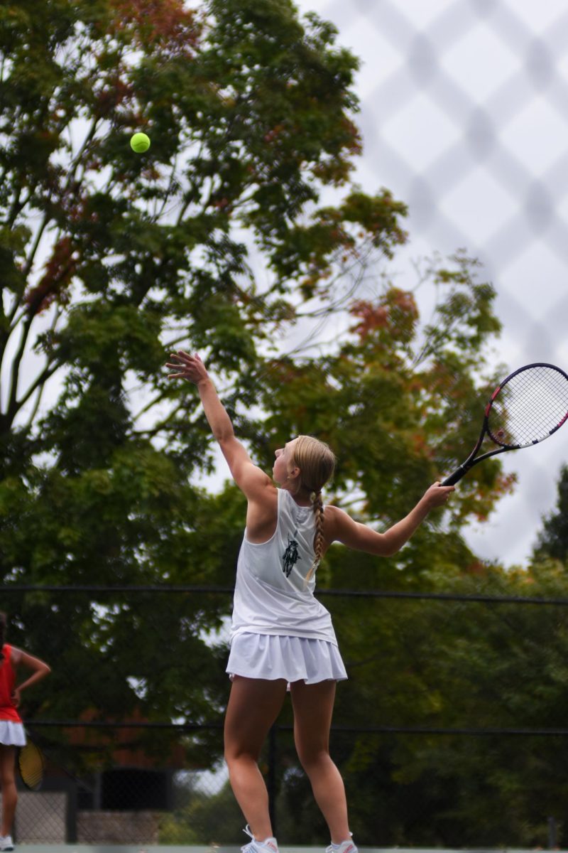 Serving in her tennis game, senior Josie Elsenraat is going against Shawnee Mission West at Harmon Park on Sept. 24.