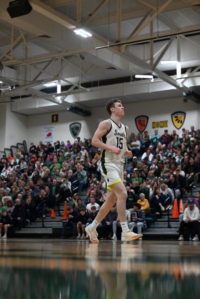 Back pedaling up the court senior Jadon Sautter celebrates scoring a basket during a home against against Olathe South on March 7.