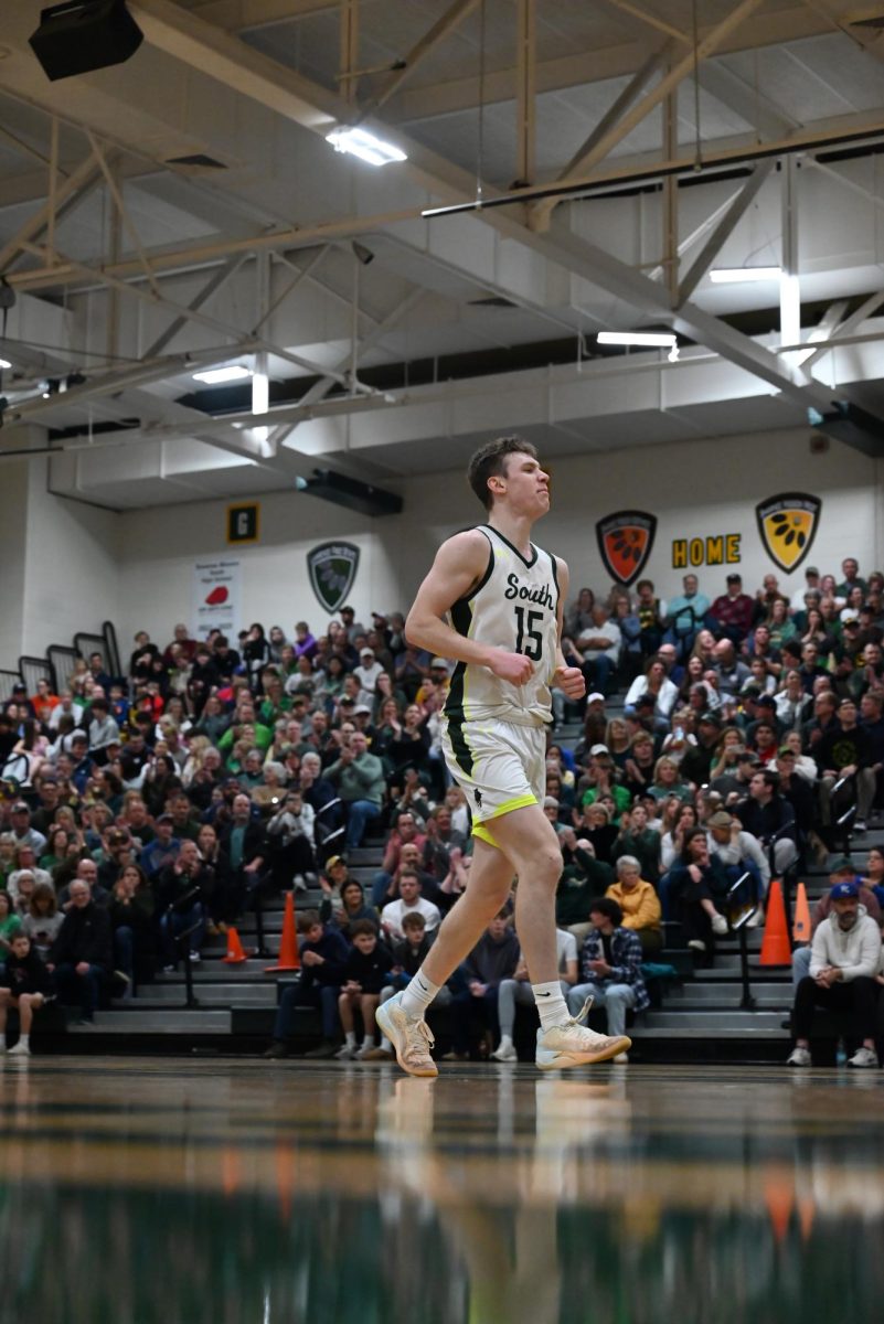 Back pedaling up the court senior Jadon Sautter celebrates scoring a basket during a home against against Olathe South on March 7.