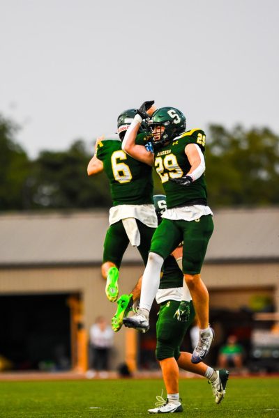 Senior Solomon Hirsch and junior Rowan Minnick celebrate after Minnick forced a fumble during the season opener against Olathe North on Thursday Sept. 4.
