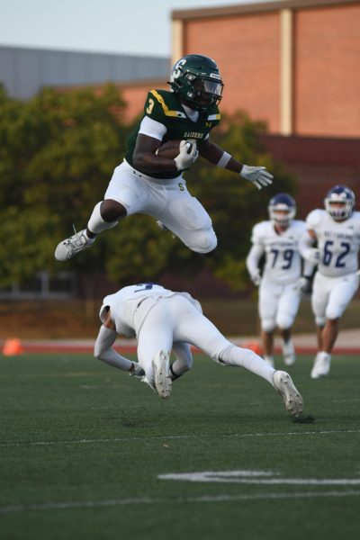 Senior Marquan Washington hurdlers a defender on Friday, Sept 12 at home against Pittsburg