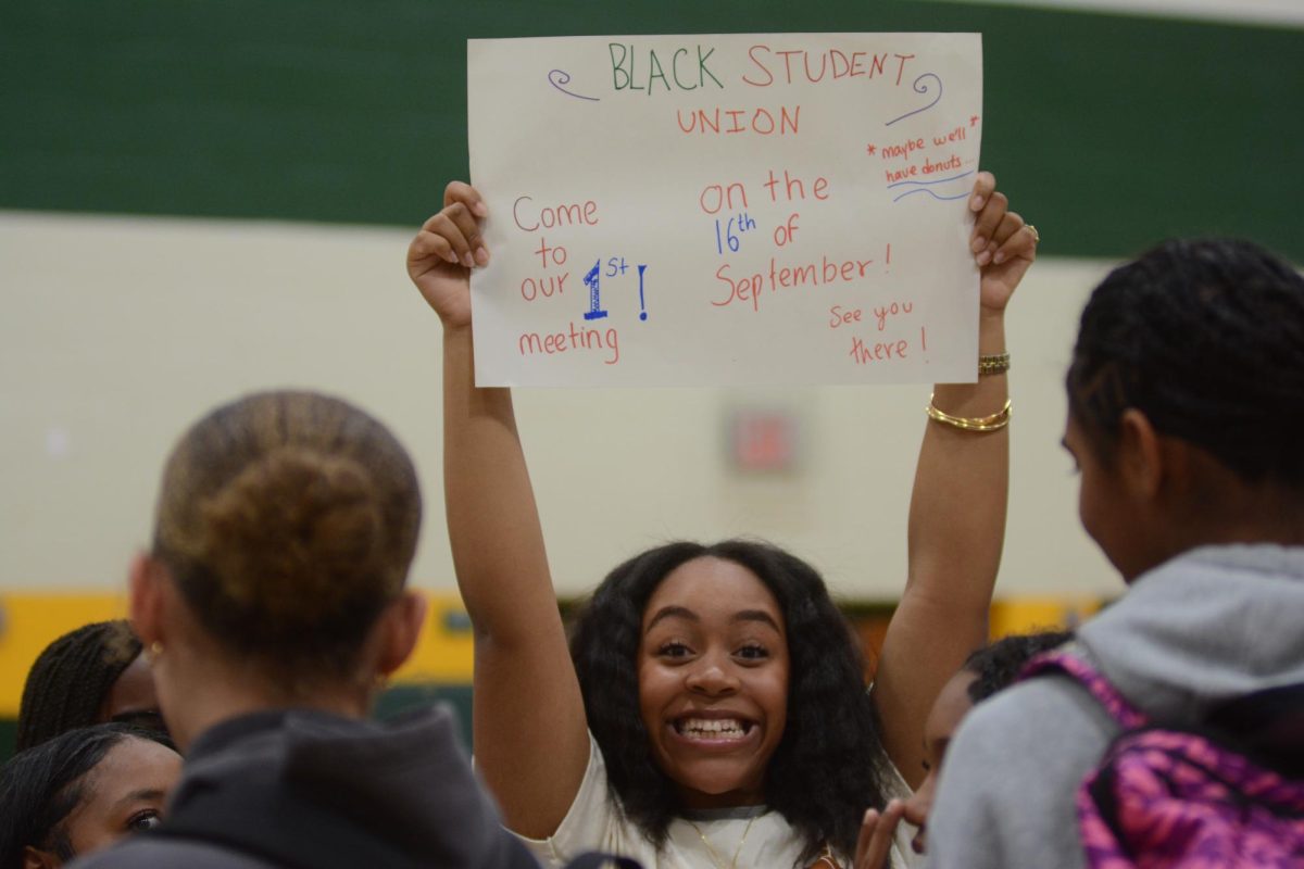 Junior Sahara Montgomery holding up a sign for Black Student Union at the Freshmen Activity Fair. 