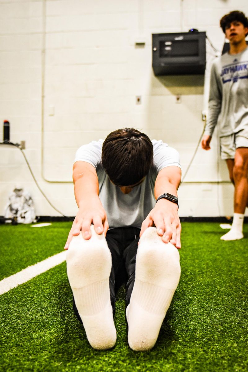 Starting off with a stretch. Everyday in coach Johnsons weights class, students start off with a dynamic stretch. Freshman Connor Griffin stretched his hamstrings out  to prepare for squat day. "stretching helps with range of motion and prevents injury." -Griffin said