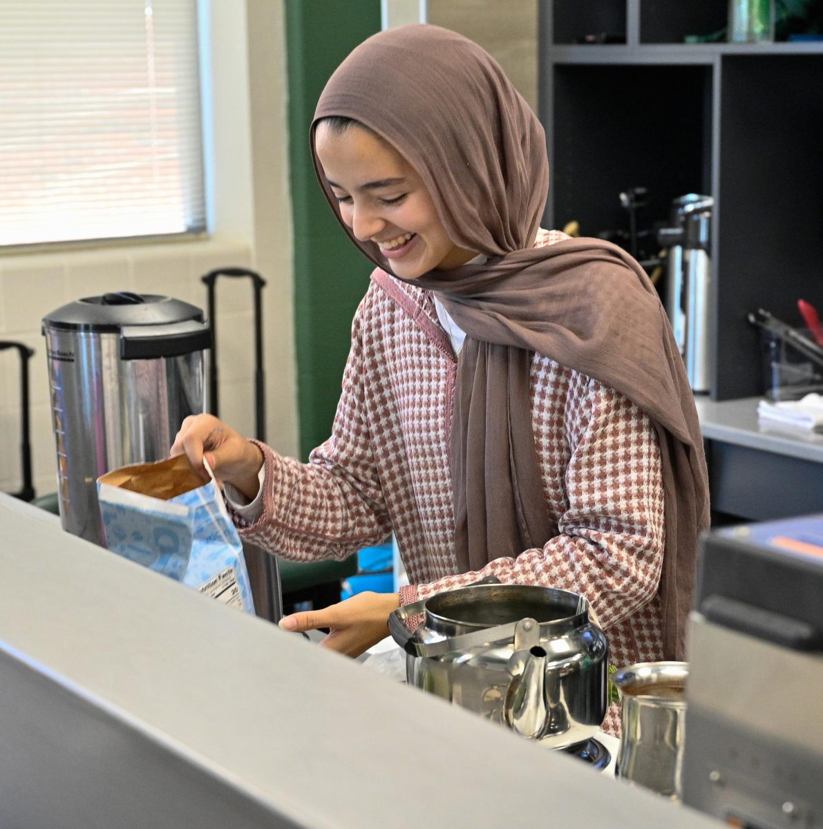 Brewing homemade tea, junior Heba Boullaouz makes Moroccan tea during the Arabic festival on November 11. Boullaouz volunteered at the festival and used many ingredients to make it just right. “ My mom makes it all the time, and we had different ingredients here at school, but I knew how to make it taste right,” Boullaouz said.