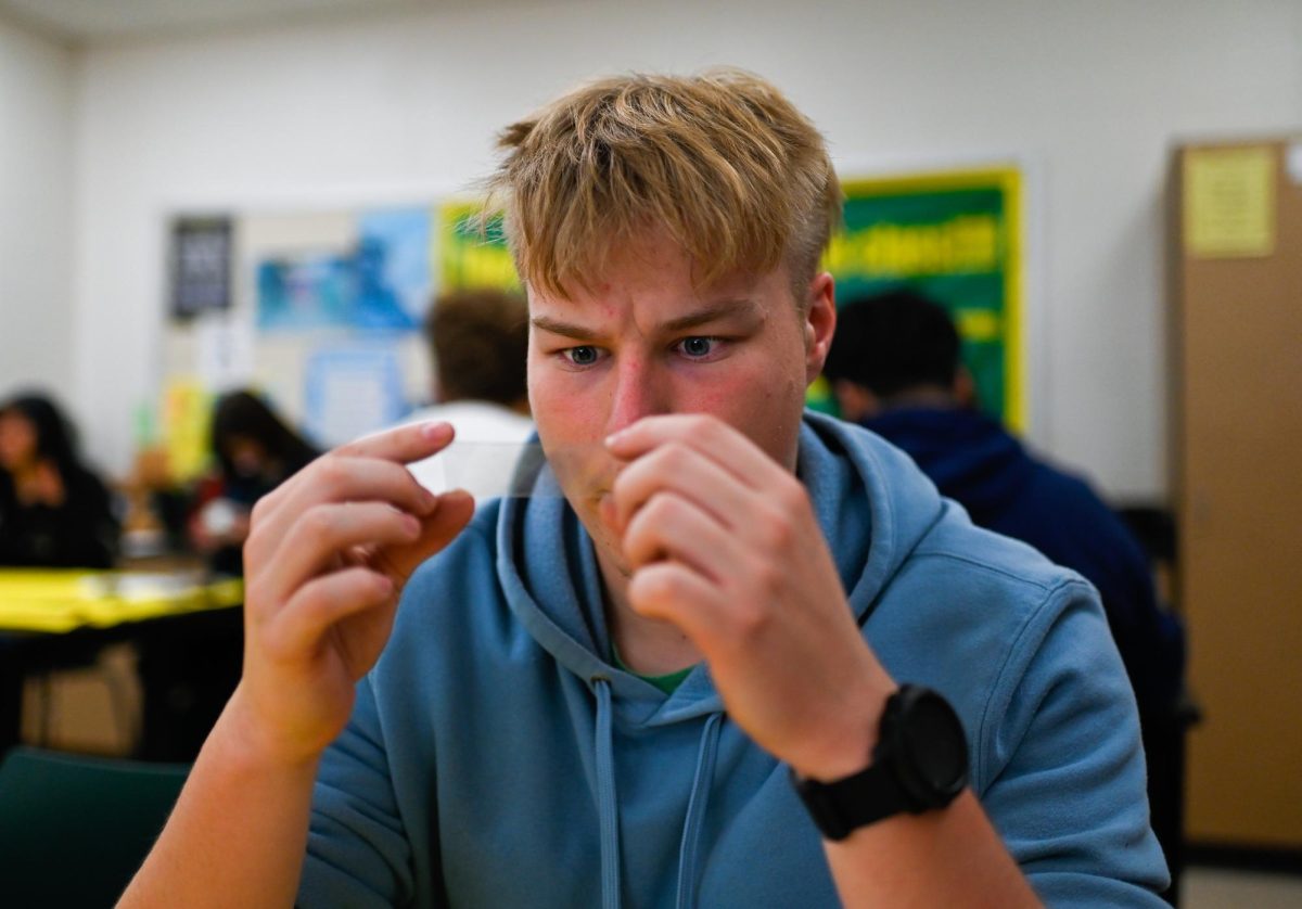 Studying his freshly made fingerprint, Hudson Witbroad is performing a fingerprint analysis in forensic science class on November 11. Witbroad talks about how "different this class is" and how he thinks it's very cool that South is teaching this kind of material. 