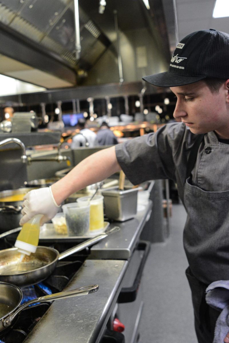 oiling up the pan junior cooper Lichtenauer prepares the pan to cook up some fish for the customers at the CAA on November 5th