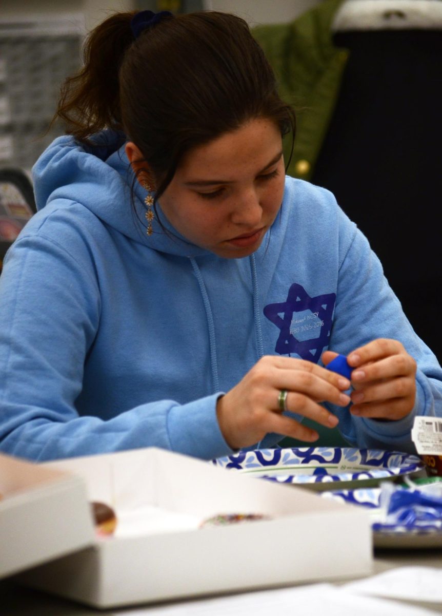 Modeling contentedly, senior Orli White focuses on creating her own dreidel out of clay. The Jewish Student Union celebrated Hanukkah after school in room 171 on Dec. 4, 2025 during their last meeting before winter break. ”I like JSU because it gives me the opportunity to connect with others and thrive in my school community,” Orli says.