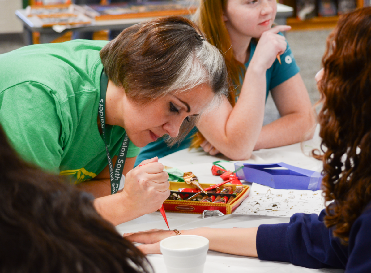 Arabic teacher Annie Hasan helps out at the henna booth of the Arabic festival on Nov.10.