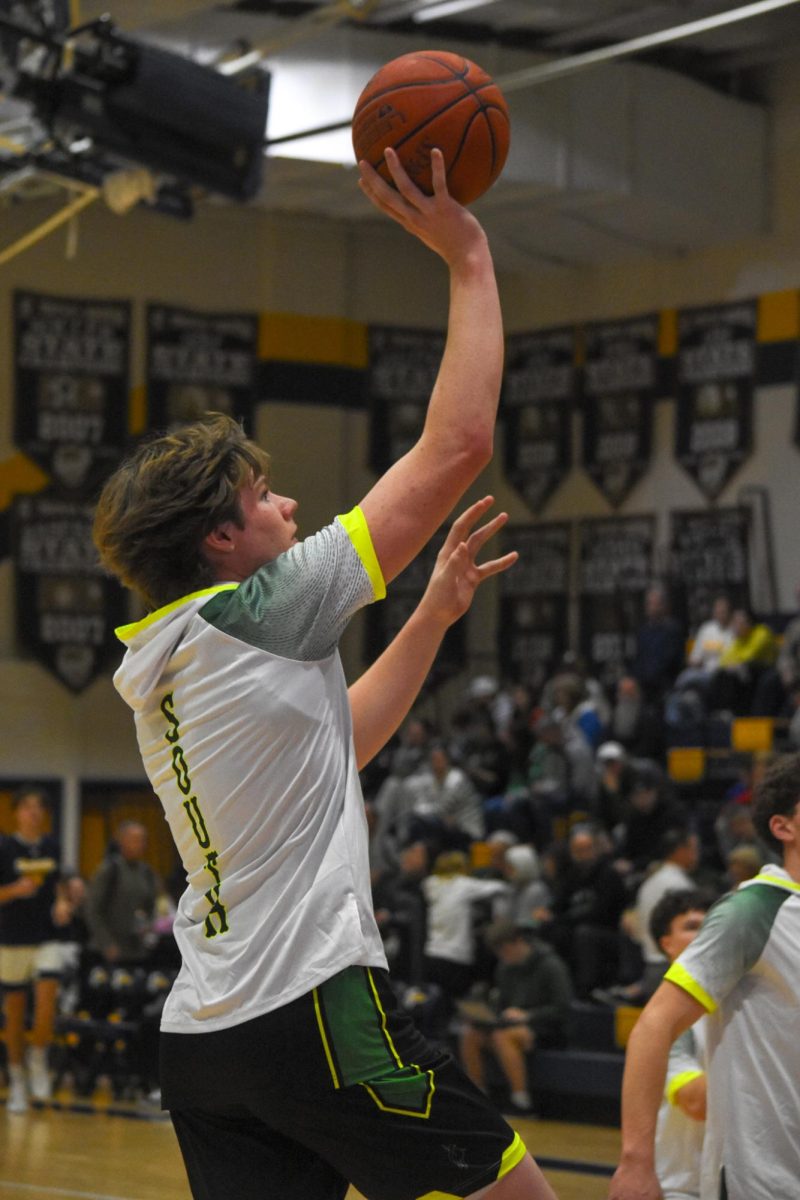 Leaping to make a jump shot, Senior, Drake DuBaun practices before the game begins. Thursday, December 9th