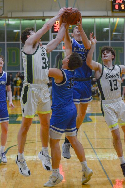 battling for control juniors conner kerrigan and rowan minnick are fighting for control of the ball againts gardener edgerton after a miss shot from the opposing team in the first quarter.