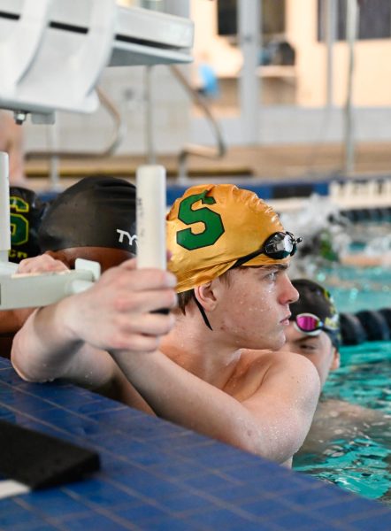 Waiting for warm-ups to start, junior Liam Farnen waits to do laps before the Swim and Dive meet against Shawnee Mission East at the Shawnee Mission Aquatic Center on Jan 15.
