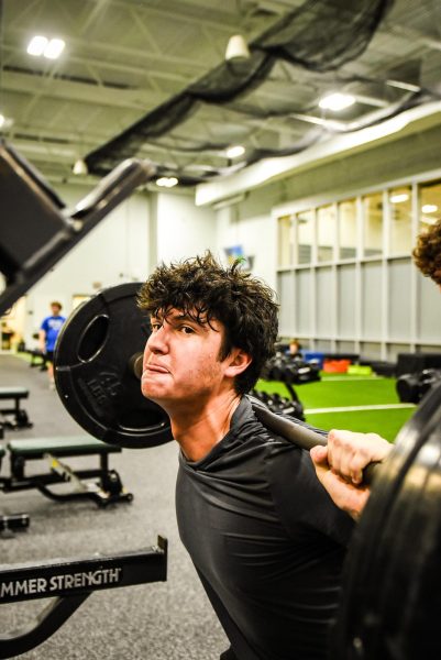 Junior Manny Torres squats during weights class.