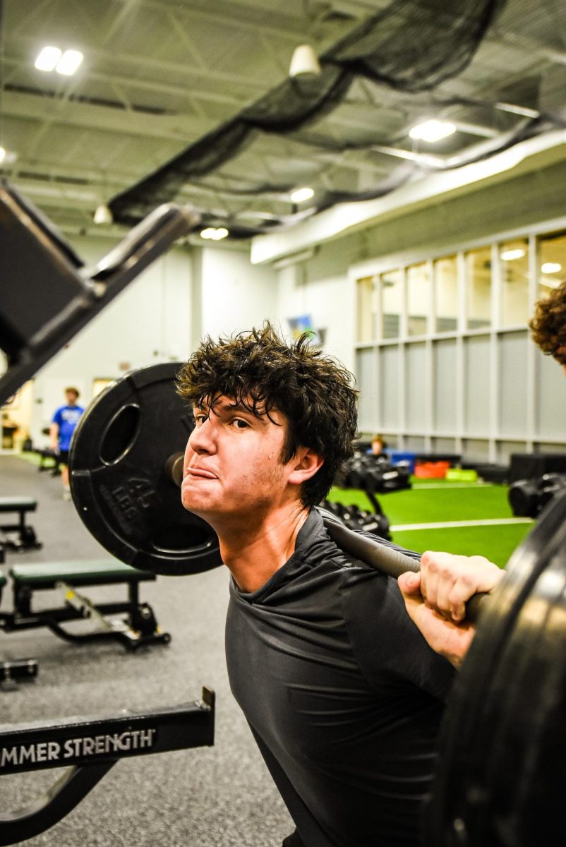 Junior Manny Torres squats during weights class.