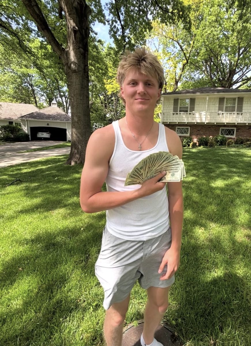 Senior Max McKenna stands with his cash prize for winning Gotcha.